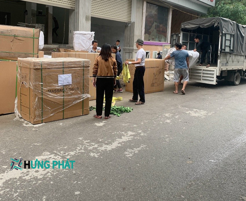 8 người đang bốc xếp các thùng hàng to lên xe tải