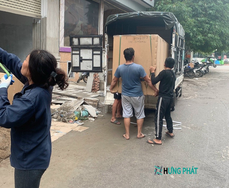 ba người bốc xếp thùng giấy to lên xe tải