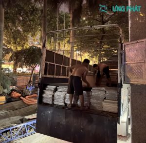 2 người đang bốc xếp hàng trên xe tải ban đêm