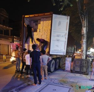 7 người đang bốc xếp thùng hàng trên thùng xe xuống